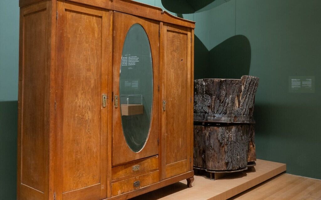 Une armoire transpercée par une baïonnette (avec un trou dans la partie supérieure droite) et un tronc d'arbre dans lequel un jeune homme s'était caché pour échapper aux nazis sont deux des objets exposés dans l'exposition "Living Memory" (Mémoire vivante) de Yad Vashem. (Crédit : Yad Vashem)