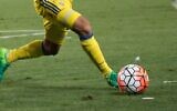 Un joueur du Maccabi Tel Aviv frappe le ballon pendant un match. (Crédit : Yonatan Sindel/Flash90)