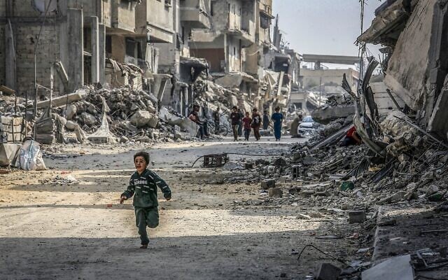 Un enfant gazaoui courant devant des bâtiments détruits pendant la guerre de Gaza, à Khan Younès, dans le sud de la bande de Gaza, le 6 novembre 2025. (Crédit : Abed Rahim Khatib/Flash90) Un enfant gazaoui courant devant des bâtiments détruits pendant la guerre de Gaza, à Khan Younès, dans le sud de la bande de Gaza, le 6 novembre 2025. (Crédit : Abed Rahim Khatib/Flash90)