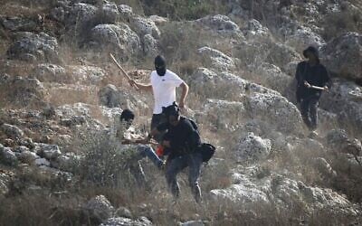 Des résidents d'implantations israéliens agressent des journalistes pendant la saison de la récolte des olives dans le village de Beita, au sud de Naplouse, en Cisjordanie, le 8 novembre 2025. (Crédit : Nasser Ishtayeh/Flash90)