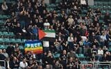 Des manifestants anti-israéliens brandissent des drapeaux palestiniens et une pancarte sur laquelle on peut lire "Carton rouge à Israël" pour protester contre la participation d'Israël à des événements sportifs, à l'extérieur d'un match de basket-ball entre Virtus Bologne et Maccabi Tel Aviv à Bologne, en Italie, le 21 novembre 2025. (Capture d'écran : Il Fatto Quotidiano)