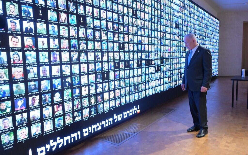 Le Premier ministre Benjamin Netanyahu rend hommage aux victimes de la guerre contre le Hamas à Gaza, devant un mur sur lequel sont affichés les visages des victimes, à la Bibliothèque nationale d’Israël à Jérusalem, le 12 octobre 2025. (Crédit : Amos Ben Gershom/GPO)