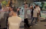 Un homme est interpellé par des policiers en civil après être resté silencieusement debout devant des manifestants d'extrême droite lors d'une manifestation à Tel Aviv, le 22 novembre 2025. (Crédit : Capture d'écran/X)