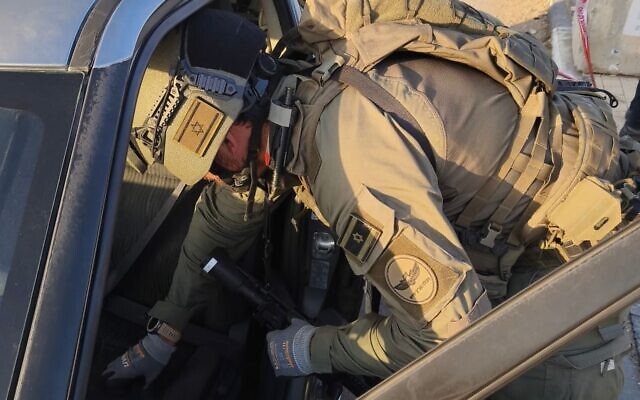 Des démineurs de la police des frontières inspectant une voiture appartenant à deux terroristes palestiniens à la suite d'une attaque au carrefour du Gush Etzion en Cisjordanie, le 18 novembre 2025. (Crédit : Police israélienne)