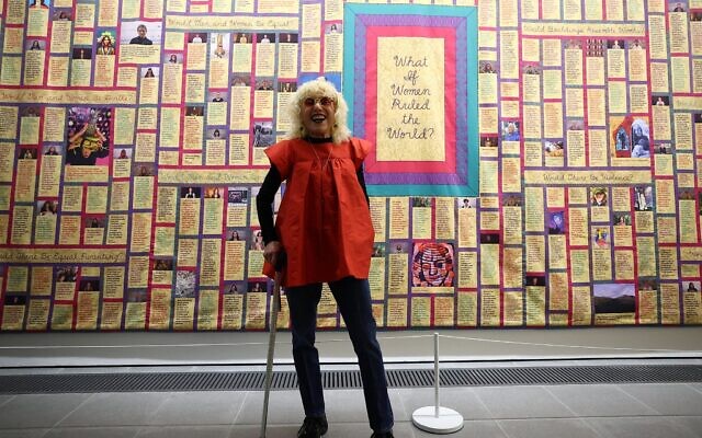 Judy Chicago se tient devant l'une de ses œuvres intitulée « What if Women Ruled the World » (Et si les femmes dirigeaient le monde) lors d'une avant-première presse pour l'exposition « Judy Chicago : Revelations » à la galerie Serpentine North à Londres, le 21 mai 2024. (Crédit : Photo par HENRY NICHOLLS / AFP)