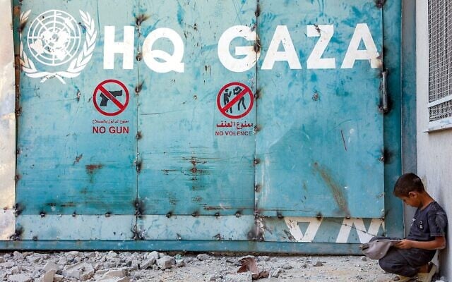 Un enfant assis devant l'entrée du complexe immobilier de l'Office très controversé de secours et de travaux des Nations unies pour les réfugiés de Palestine dans le Proche-Orient (UNRWA), à Gaza-City, le 6 septembre 2025. (Crédit : Omar al-Qattaa/AFP) Un enfant assis devant l'entrée du complexe immobilier de l'Office très controversé de secours et de travaux des Nations unies pour les réfugiés de Palestine dans le Proche-Orient (UNRWA), à Gaza-City, le 6 septembre 2025. (Crédit : Omar al-Qattaa/AFP)