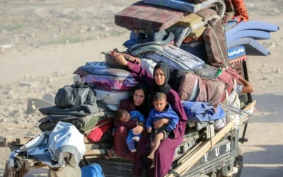 Venues de Nuseirat, des femmes palestiniennes avec leurs enfants dans les bras se rendent à Gaza, le 11 octobre 2025. (Eyad Baba/AFP)