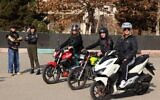 L'instructrice iranienne Maryam Ghelich se tient aux côtés de son élève Narghes alors qu'elles regardent Elham (3e à droite), Leila et Mona, posant sur leurs motos avant leur cours dans un centre de formation au nord de Téhéran, le 7 décembre 2025. (Crédit : ATTA KENARE / AFP)