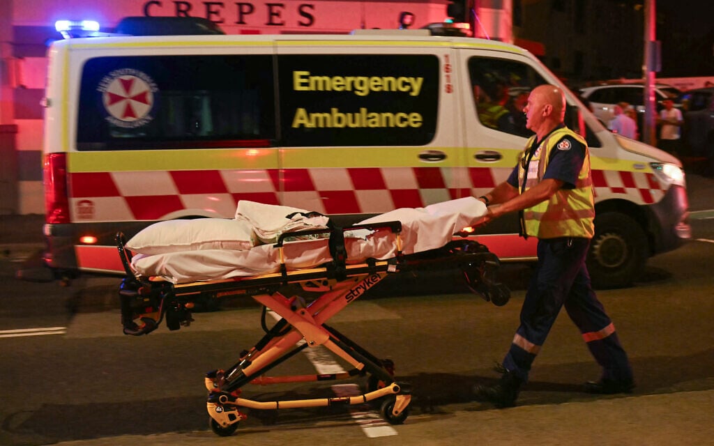 Un secouriste déplace un brancard après une fusillade survenue à Bondi Beach, à Sydney, visant un allumage de la fête de Hanoukka, le 14 décembre 2025. (Crédit : Saeed Khan / AFP)
