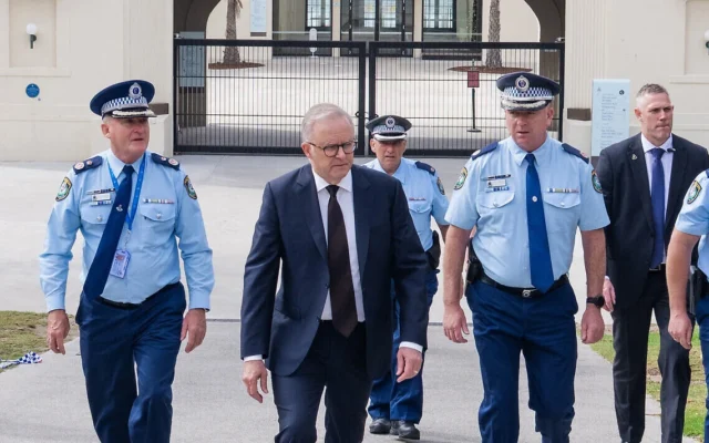 Le Premier ministre australien Anthony Albanese aux côtés de policiers après avoir déposé des fleurs au Bondi Pavilion, sur les lieux de l'attentat terroriste perpétré lors d'un événement de Hanoukka, à Sydney, le 15 décembre 2025. (Crédit : Document fourni par le bureau du Premier ministre australien/AFP)