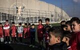 Des jeunes Palestiniens déplacés participent à une séance d'entraînement sur le terrain de football du camp de réfugiés d'Aida, à côté de la barrière de sécurité israélienne à l'extérieur de Bethléem, en Cisjordanie, le 16 décembre 2025, quelques semaines après la décision de l'armée israélienne de démolir le terrain. (Crédit : Photo de JOHN WESSELS / AFP)