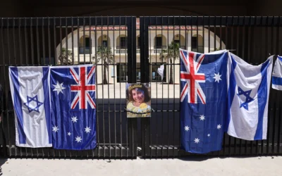 Une affiche représentant Matilda, 10 ans, tuée lors de l'attentat terroriste de Bondi Beach, accrochée à côté des drapeaux australien et israélien sur la porte du Bondi Pavilion, à Sydney, le 18 décembre 2025. (Crédit : David Gray/AFP)