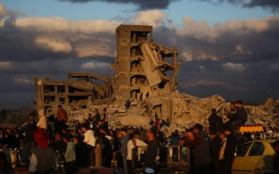 Des Palestiniens déplacés se tiennent à côté de maisons détruites dans le camp de Nuseirat, dans le centre de la bande de Gaza, le 19 décembre 2025. (Crédit : Eyad Baba / AFP)