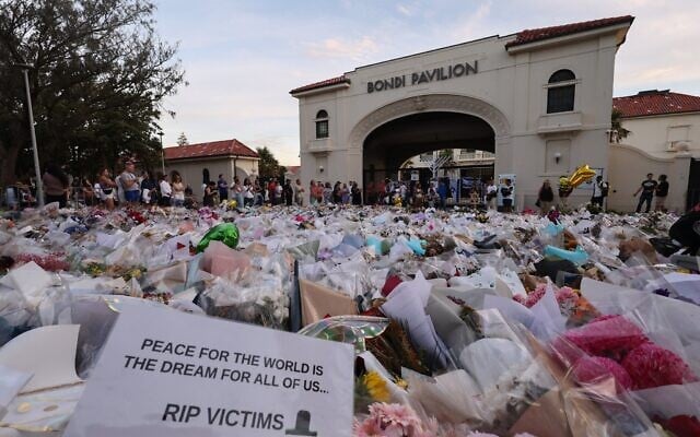 Une note est visible à côté des fleurs déposées au Bondi Pavilion en mémoire des victimes d'une fusillade terroriste visant un événement juif quelques jours plus tôt, à Bondi Beach, à Sydney, en Australie, le 20 décembre 2025. (Crédit : David Gray/AFP)