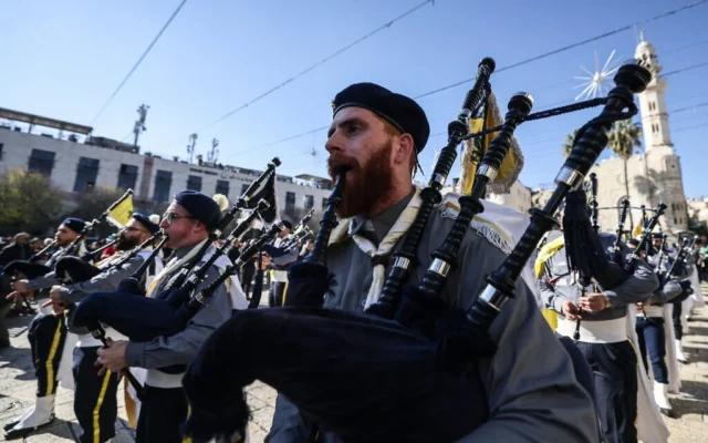 Des membres du mouvement scout défilent lors des célébrations de la veille de Noël sur la place de la Mangeoire, devant l'église de la Nativité à Bethléem, en Cisjordanie, le 24 décembre 2025. (Crédit : HAZEM BADER / AFP) Des membres du mouvement scout défilent lors des célébrations de la veille de Noël sur la place de la Mangeoire, devant l'église de la Nativité à Bethléem, en Cisjordanie, le 24 décembre 2025. (Crédit : HAZEM BADER / AFP)
