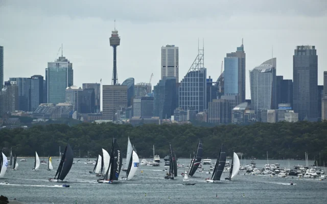 Des voiliers s'affrontent au départ de la course annuelle Sydney-Hobart dans le port de Sydney le 26 décembre 2025. (Crédit : Saeed KHAN / AFP)