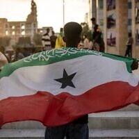 Illustration : Un homme couvert un drapeau du Somaliland devant le monument commémoratif de la guerre, à Hargeisa, le 7 novembre 2024. (Crédit : Luis Tato/AFP)