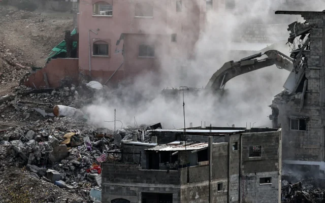 Une pelleteuse militaire israélienne démolit l'un des 25 bâtiments résidentiels destinés à la démolition dans le camp de réfugiés palestiniens de Nur Shams, à l'est de la ville de Tulkarem, dans le nord de la Cisjordanie, le 31 décembre 2025. (Crédit : Zain JAAFAR / AFP)