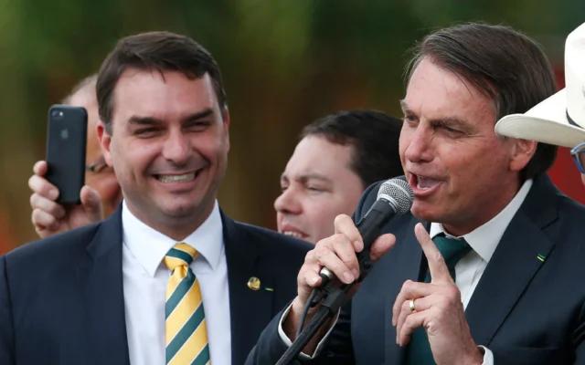 Le sénateur brésilien Flavio Bolsonaro, à gauche, regarde son père, alors président Jair Bolsonaro, lancer un nouveau parti politique, l'Alliance pour le Brésil, à Brasilia, au Brésil, le 21 novembre 2019. (Crédit: AP Photo/Eraldo Peres)