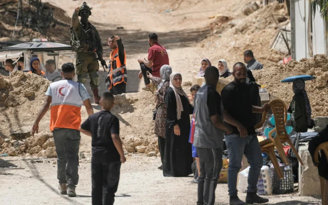 Un soldat israélien monte la garde tandis que les habitants du camp de réfugiés de Nur Shams, en Cisjordanie, évacuent leurs maisons et transportent leurs biens, avant la démolition prévue de leurs habitations par les forces de sécurité israéliennes le 6 mai 2025. (Crédit : AP Photo/Majdi Mohammed)