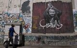 Un homme passant devant une fresque murale représentant le terroriste palestinien condamné à la perpétuité, Marwan Barghouti, avec un message en arabe qui dit « À bientôt », sur la barrière de sécurité israélienne, à Bethléem, en Cisjordanie, le 20 août 2025. (Crédit : Mahmoud Illean/AP)