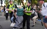 Des policiers évacuant une manifestante lors d'un rassemblement en soutien au groupe terroriste Palestine Action, à Londres, le 6 septembre 2025. (Crédit : Joanna Chan/AP Photo)