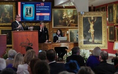 Le commissaire-priseur Jean-Pierre Osenat fait un geste alors que le tableau « La Crucifixion de Jésus-Christ » du maître baroque Peter Paul Rubens, disparu depuis longtemps, vendu aux enchères Osenat, à Versailles, à l'ouest de Paris, le 30 novembre 2025. (Crédit : Michel Euler/AP Photo)