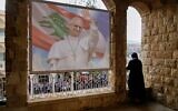 Une religieuse regardant depuis un balcon alors que les gens attendent l'arrivée du pape Léon XIV, à l'hôpital De la Croix, à Jal el Dib, au Liban, le 2 décembre 2025. (Crédit : Hassan Ammar/AP)