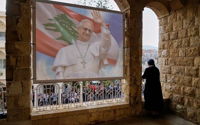 Une religieuse regardant depuis un balcon alors que les gens attendent l'arrivée du pape Léon XIV, à l'hôpital De la Croix, à Jal el Dib, au Liban, le 2 décembre 2025. (Crédit : Hassan Ammar/AP) Une religieuse regardant depuis un balcon alors que les gens attendent l'arrivée du pape Léon XIV, à l'hôpital De la Croix, à Jal el Dib, au Liban, le 2 décembre 2025. (Crédit : Hassan Ammar/AP)