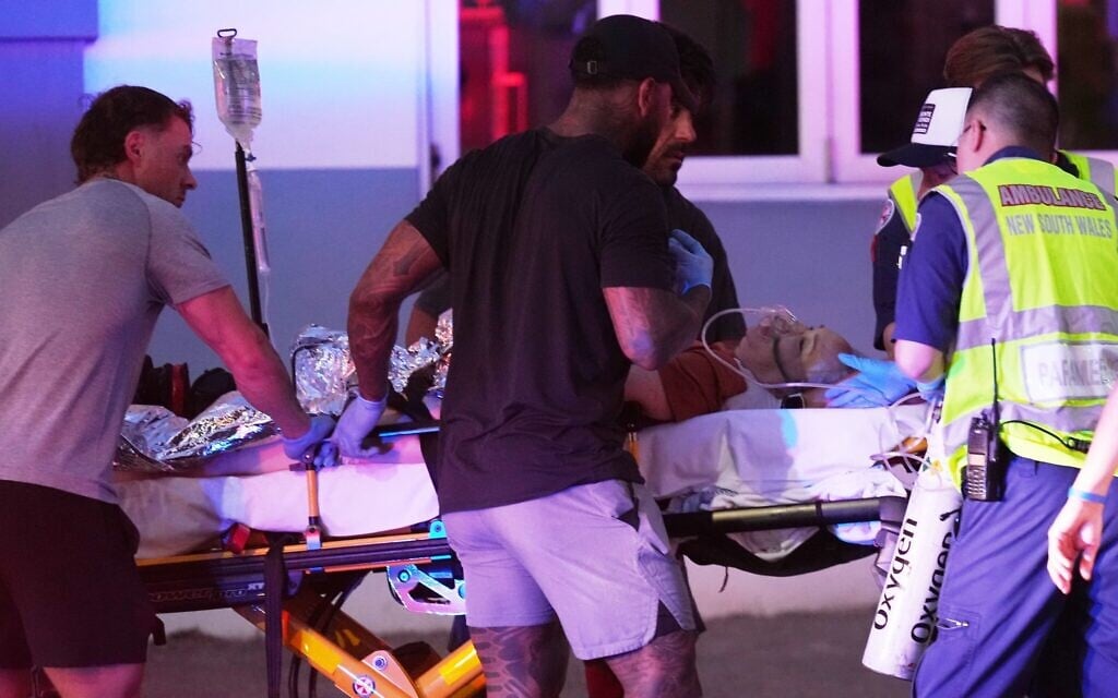 Un blessé sur une civière après une fusillade lors d'un événement organisé à l'occasion de Hanoukka, à Bondi Beach, à Sydney, le 14 décembre 2025. (Crédit : Mark Baker/AP Photo)