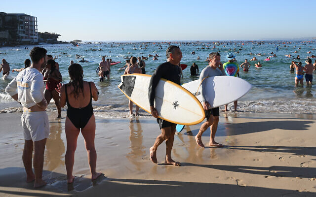 Des surfeurs et des nageurs se rendent à l'océan en hommage aux victimes de la fusillade survenue dimanche dernier à Bondi Beach, à Sydney, vendredi 19 décembre 2025. (Crédit : AP Photo/Steve Markham) Des surfeurs et des nageurs se rendent à l'océan en hommage aux victimes de la fusillade survenue dimanche dernier à Bondi Beach, à Sydney, vendredi 19 décembre 2025. (Crédit : AP Photo/Steve Markham)