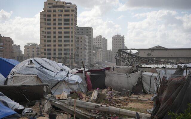 Une fillette palestinienne se tient au milieu d'un camp provisoire pour personnes déplacées à Gaza-City, dimanche 28 décembre 2025. (Crédit : AP/Jehad Alshrafi)