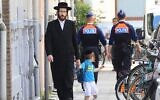 Illustration : Un Juif orthodoxe et son fils passant devant deux policiers, à Anvers, en Belgique, le 25 mai 2014. (Crédit : Yves Logghe/AP Photo)