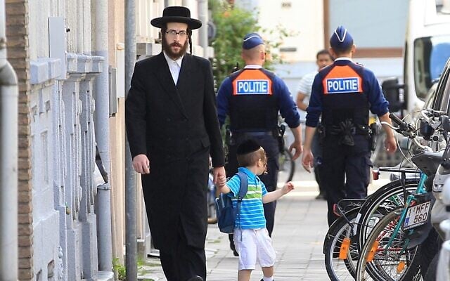 Illustration : Un Juif orthodoxe et son fils passant devant deux policiers, à Anvers, en Belgique, le 25 mai 2014. (Crédit : Yves Logghe/AP Photo) Illustration : Un Juif orthodoxe et son fils passant devant deux policiers, à Anvers, en Belgique, le 25 mai 2014. (Crédit : Yves Logghe/AP Photo)