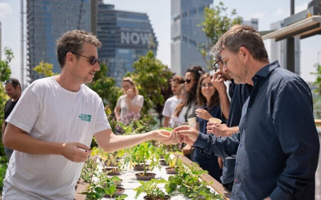 Lavi Refael, fondateur et PDG de l'Association for Urban Farming (à gauche), s'entretient avec un visiteur au jardin Azrieli à Tel Aviv (Autorisation : Association for Urban Farming)