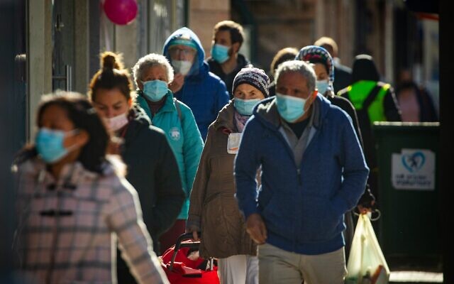 Des Israéliens portant des masques marchent dans le centre-ville de Jérusalem le 21 janvier 2021, pendant le troisième confinement national lié au coronavirus. (Crédit : Olivier Fitoussi/Flash90) Des Israéliens portant des masques marchent dans le centre-ville de Jérusalem le 21 janvier 2021, pendant le troisième confinement national lié au coronavirus. (Crédit : Olivier Fitoussi/Flash90)