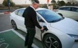 Un homme recharge sa voiture électrique à une borne de recharge à Katzrin, dans les hauteurs du Golan, le 21 janvier 2025. (Crédit : Michael Giladi/Flash90)
