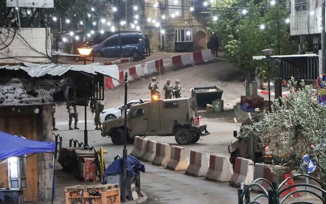 Les forces de sécurité israéliennes près du lieu d'une attaque à la voiture bélier, dans la ville cisjordanienne d'Hébron, le 6 décembre 2025. (Crédit : Wisam Hashlamoun/Flash90)