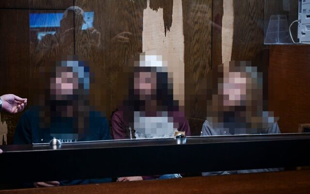 Trois suspects juifs, accusés d'avoir agressé une femme arabe enceinte à Jaffa quelques jours plus tôt, arrivent pour une audience sur la prolongation de leur détention au tribunal de Tel Aviv, le 16 décembre 2025. (Crédit : Avshalom Sassoni/Flash90)