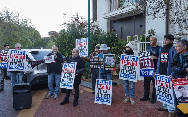 Des militants réclamant la création d'une commission d'enquête nationale sur le 7-Octobre devant le domicile du ministre de l'Éducation, Yoav Kisch, à Hod HaSharon, le 24 décembre 2025. (Crédit : Tal Gal/Flash90)