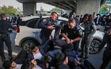 Des ultra-orthodoxes affrontant la police lors d'une manifestation bloquant la Route 4 pour protester contre l'emprisonnement d'étudiants de yeshiva qui ont refusé de se conformer à un ordre de conscription militaire, près de Bnei Brak, le 28 décembre 2025. (Crédit : David Cohen/Flash90)
