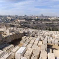 Une vue sur le cimetière du mont des Oliviers à Jérusalem, avec la Vieille Ville et le mont du Temple en arrière-plan, le 17 novembre 2025. (Crédit : Zev Stub/Times of Israel)