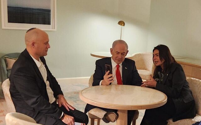 Le Premier ministre Benjamin Netanyahu, au centre, aux côtés de la ministre des Transports Miri Regev, à droite, et du directeur national de l'IA Erez Eshel, s'entretient au téléphone depuis la Floride avec le milliardaire Elon Musk, le 29 décembre 2025. (Crédit : Porte-parole du cabinet du Premier ministre)