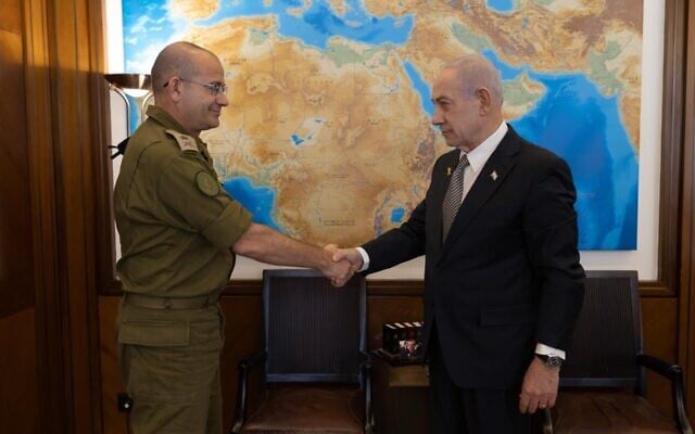 Le Premier ministre Benjamin Netanyahu (à droite) serre la main du major général Roman Gofman, son secrétaire militaire, qu’il a nommé le 4 décembre 2025 au poste de directeur du Mossad. (Crédit : Porte-parole du bureau du Premier ministre)