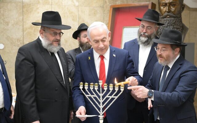 Le Premier ministre Benjamin Netanyahu allume les bougies de Hanoukka avec les émissaires de Chabad à Jérusalem, le 21 décembre 2025. (Crédit : Amos Ben Gershom/GPO)