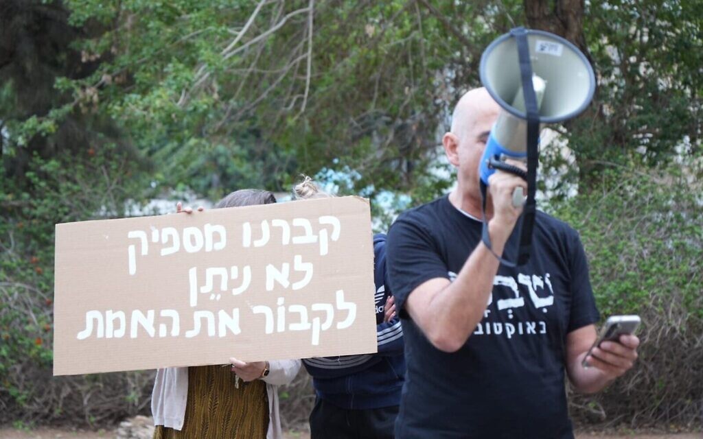 Manifestation devant le domicile du président de la Knesset Amir Ohana à Tel Aviv, le 24 décembre 2025. On peut lire sur la pancarte : "Nous avons enterré trop de choses, n'enterrez pas la vérité". (Crédit : Groupes de manifestants pour la démocratie/Lior Segev)