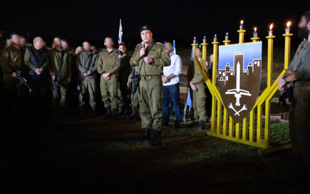 Le chef de l'armée israélienne, le lieutenant-général Eyal Zamir, allume les bougies de Hanoukka avec les soldats de la brigade Hasmonéenne, une brigade ultra-orthodoxe, le 21 décembre 2025. (Crédit : Armée israélienne)
