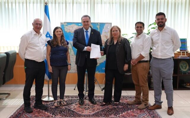 Le ministre de la Défense Israel Katz (au centre) recevant un rapport des membres d'un comité qui a examiné les activités de la radio de l'armée, le 28 octobre 2025. (Crédit : Ministère de la Défense)