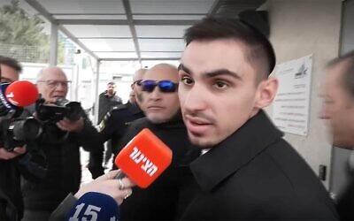 L'ancien otage Rom Braslavski s'adresse aux médias alors qu'il entre au commissariat de Tel Aviv pour témoigner d'une agression dont il aurait été victime dans la ville, le 21 janvier 2026. (Crédit : Capture d'écran/Ynet)