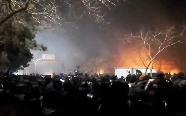 De la fumée s'élève alors que des manifestants se rassemblent dans un contexte de manifestations anti-gouvernementales croissants sur l'autoroute Vakilabad à Mashhad, dans la province de Razavi Khorasan, en Iran, le 10 janvier 2026, comme le montre cette capture d'écran tirée d'une vidéo publiée sur les réseaux sociaux. (Crédit : RÉSEAUX SOCIAUX/via REUTERS)